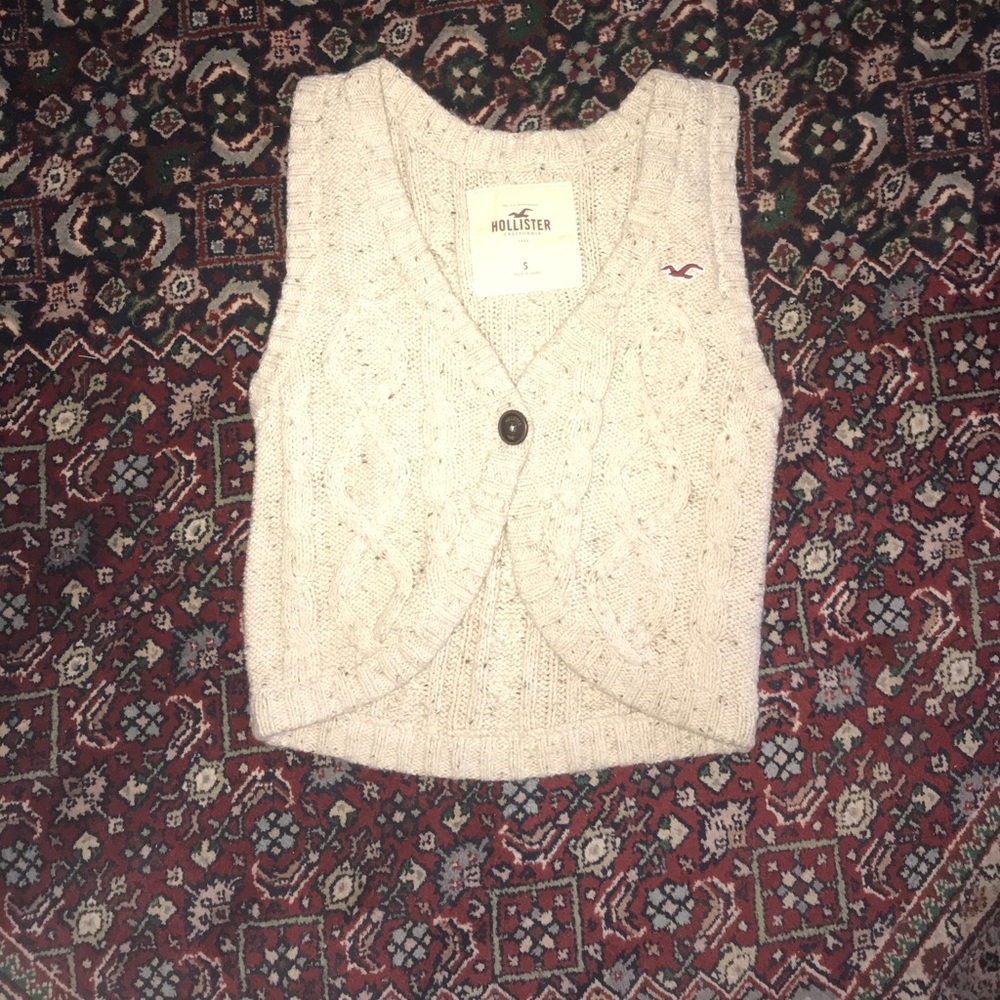 Cable knit sweater vest. Single wooden button.
